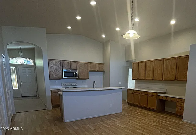 a kitchen with stainless steel appliances kitchen island granite countertop a stove a sink and a refrigerator