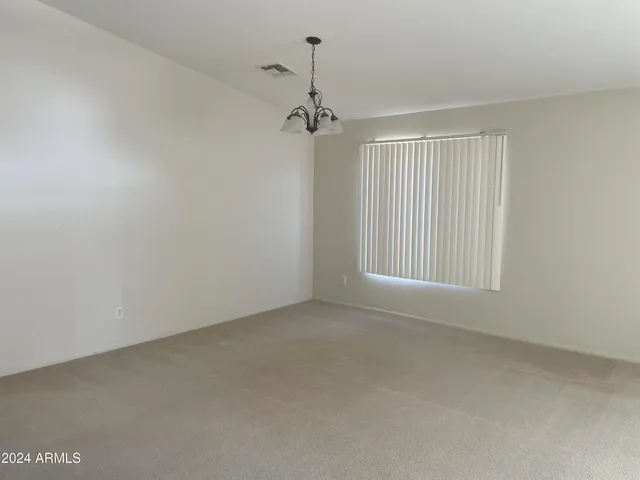 an empty room with windows and cabinet