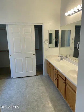 a spacious bathroom with a granite countertop sink and a mirror