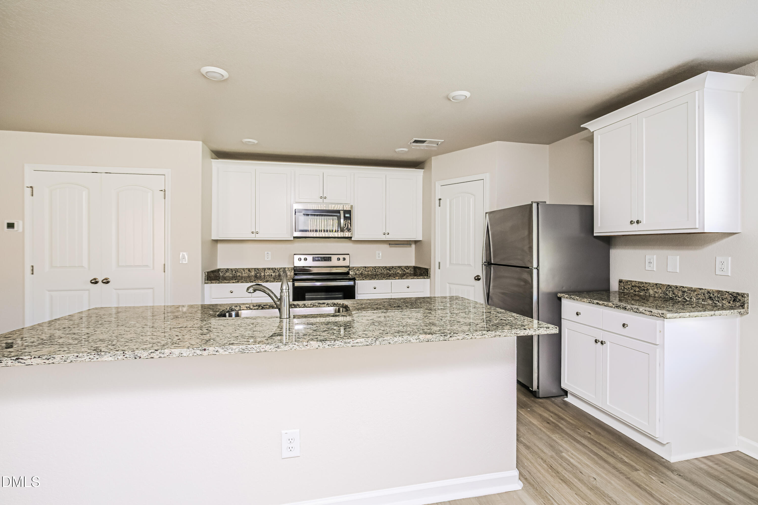 135 Shallow Drive Youngsville, NC 27596 - Photo 5 of 17 a kitchen with stainless steel appliances a refrigerator sink stove and white cabinets