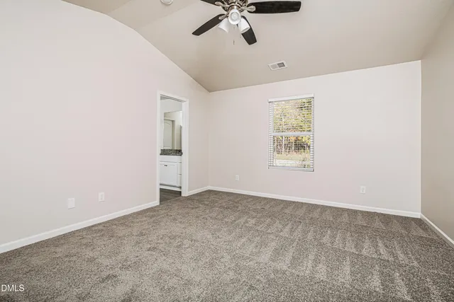 an empty room with a ceiling fan and carpet
