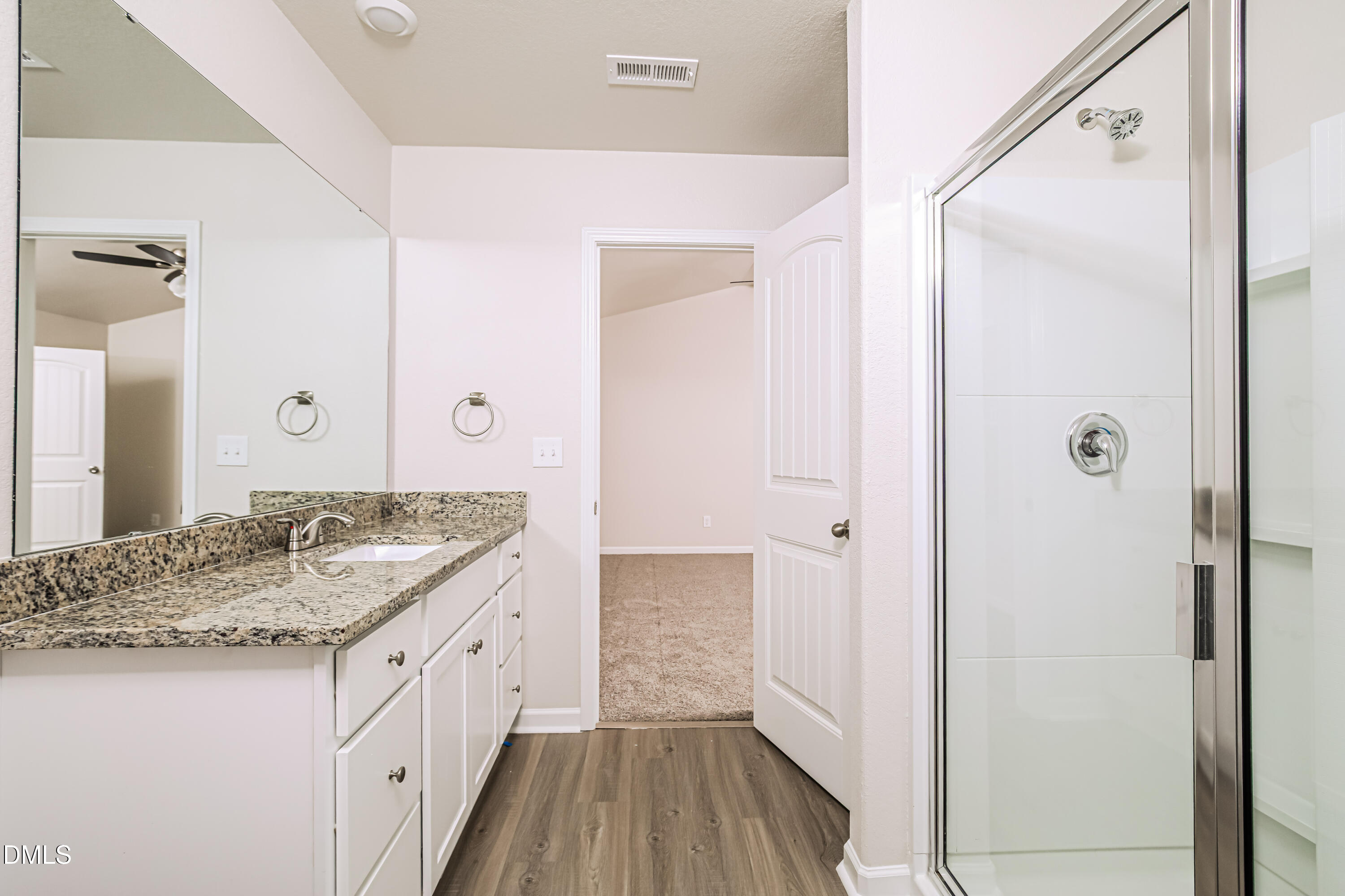 135 Shallow Drive Youngsville, NC 27596 - Photo 10 of 17 a bathroom with a granite countertop sink a mirror and shower