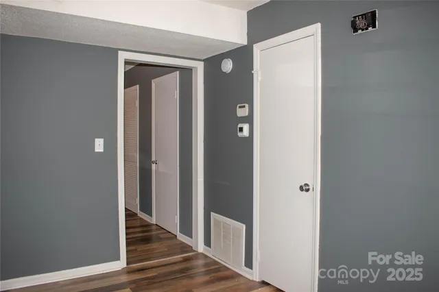 a view of an empty room with wooden floor