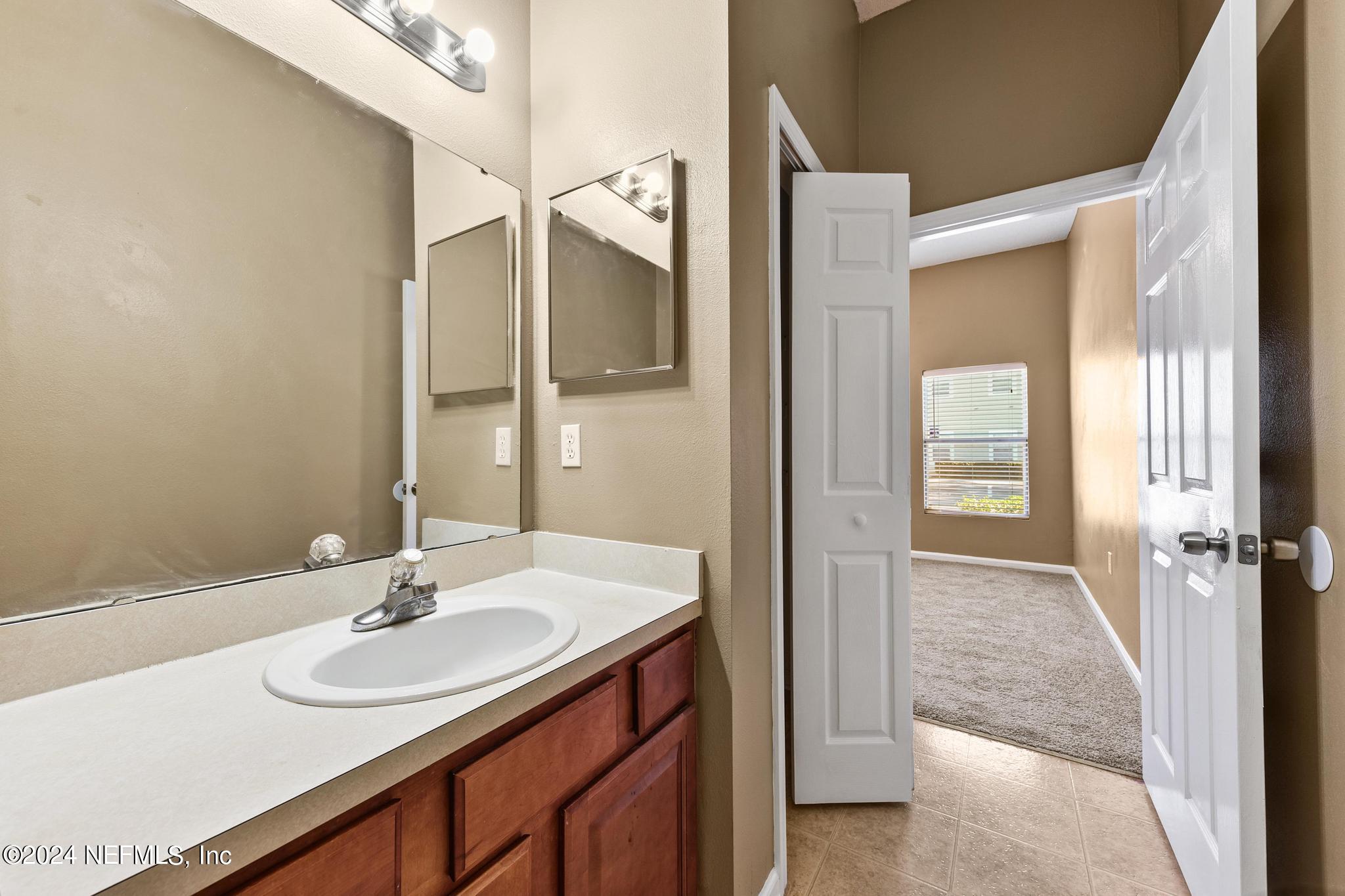 7920 Merrill Road, Unit 2205 Jacksonville, FL 32277 - Photo 12 of 21 a bathroom with a sink and a mirror