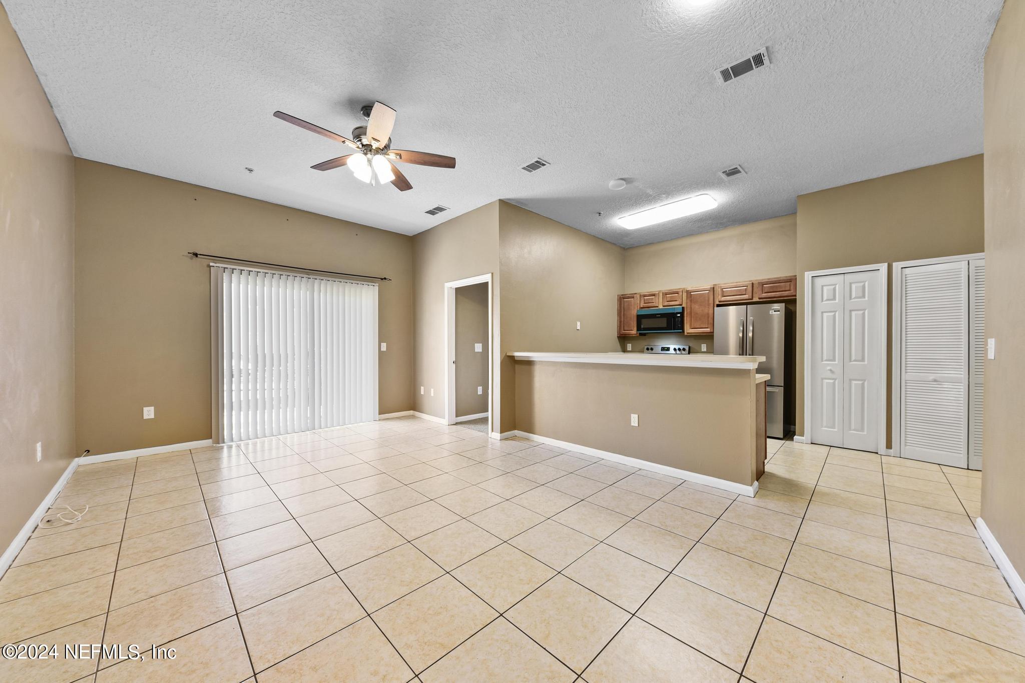 7920 Merrill Road, Unit 2205 Jacksonville, FL 32277 - Photo 2 of 21 a view of a kitchen with a sink and a refrigerator