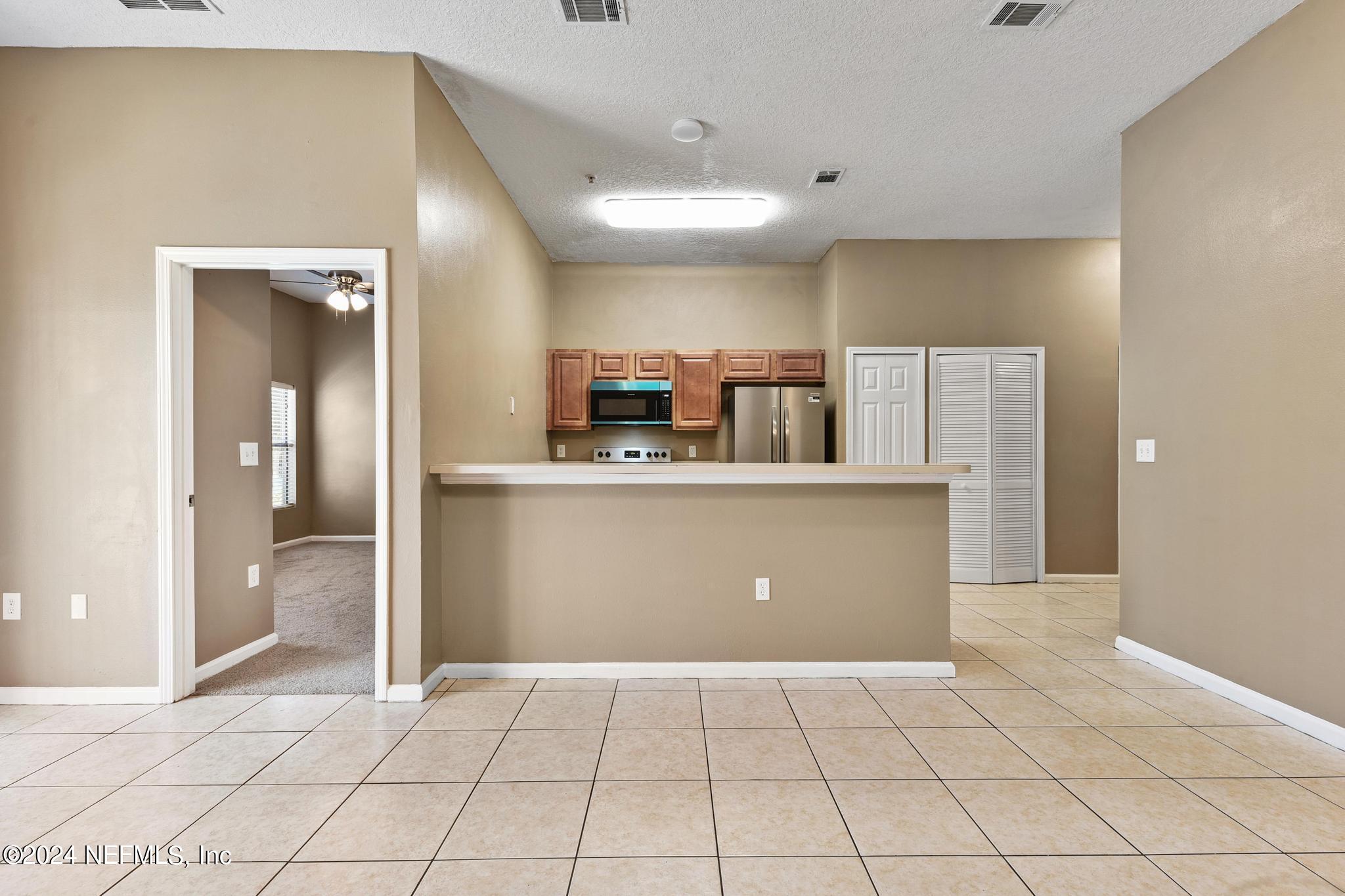 7920 Merrill Road, Unit 2205 Jacksonville, FL 32277 - Photo 4 of 21 a view of a kitchen with a sink and a refrigerator