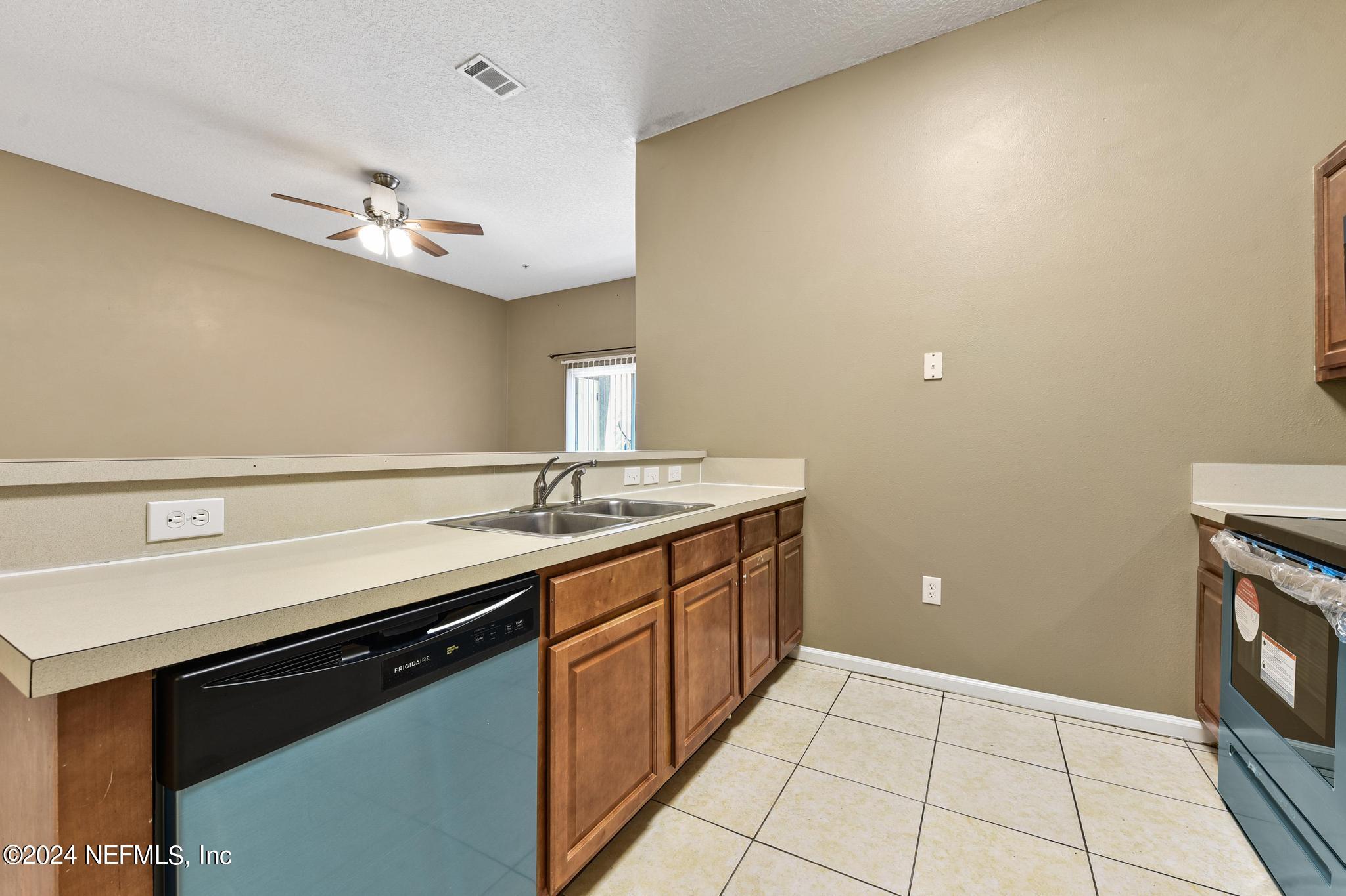 7920 Merrill Road, Unit 2205 Jacksonville, FL 32277 - Photo 5 of 21 a kitchen with a sink and a stove