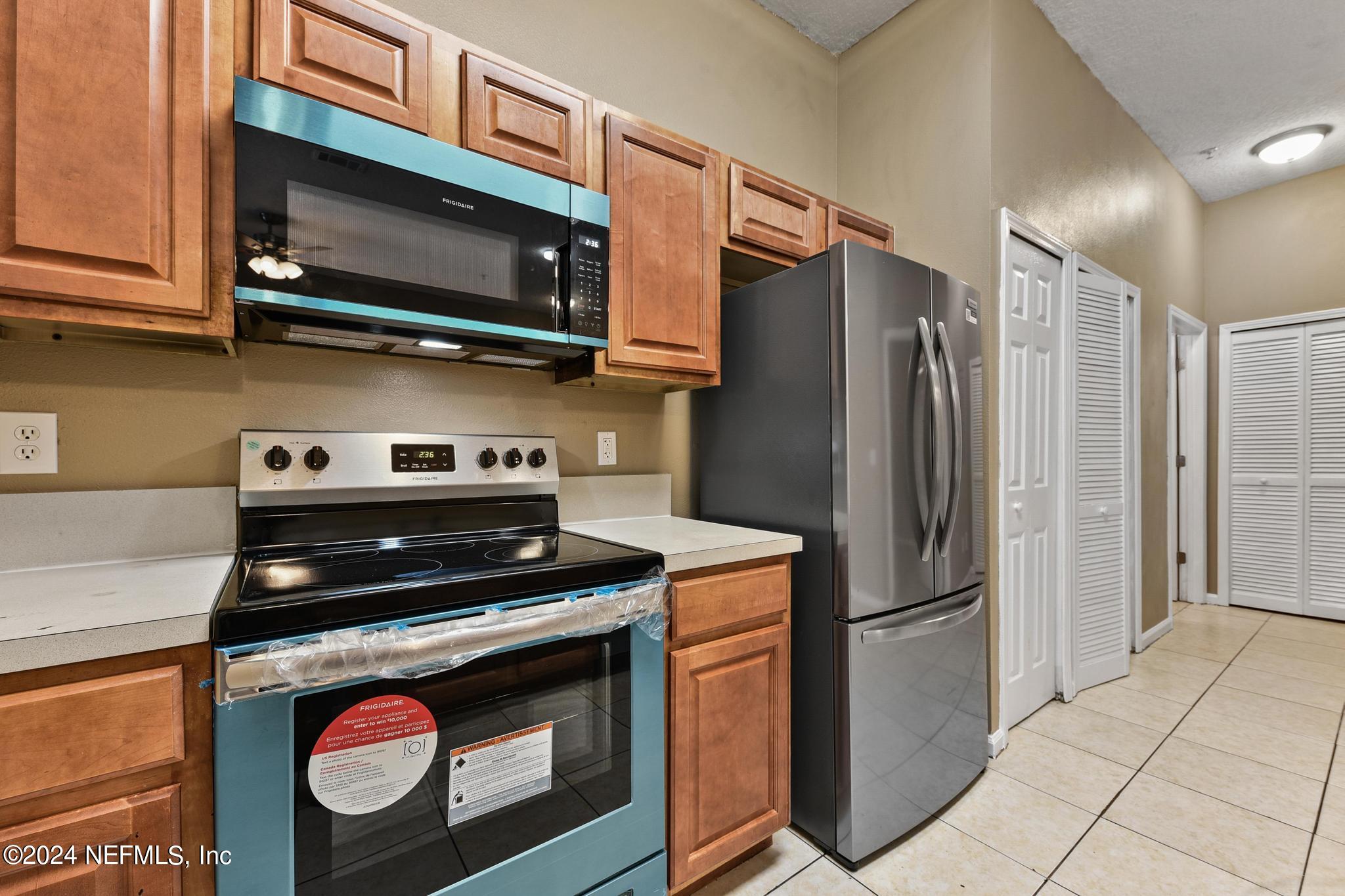 7920 Merrill Road, Unit 2205 Jacksonville, FL 32277 - Photo 6 of 21 a kitchen with stainless steel appliances granite countertop a stove microwave and refrigerator