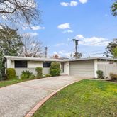 a front view of house with yard and trees around