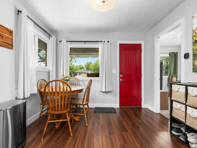 225 South 300 East Provo, UT 84606 - Photo 2 of 30 Bright room featuring rich wood-finish flooring, a vibrant red entry door, and multiple windows with white trim