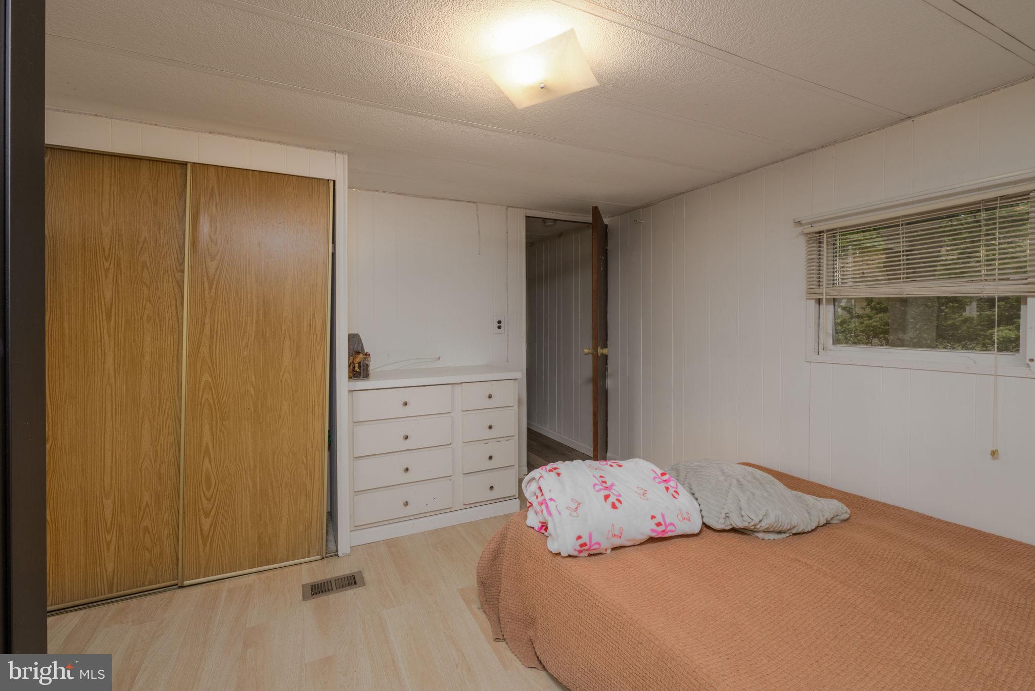 27284 Cottage Road, Unit 9182 Millsboro, DE 19966 - Photo 11 of 18 a bedroom with a bed and a cabinets