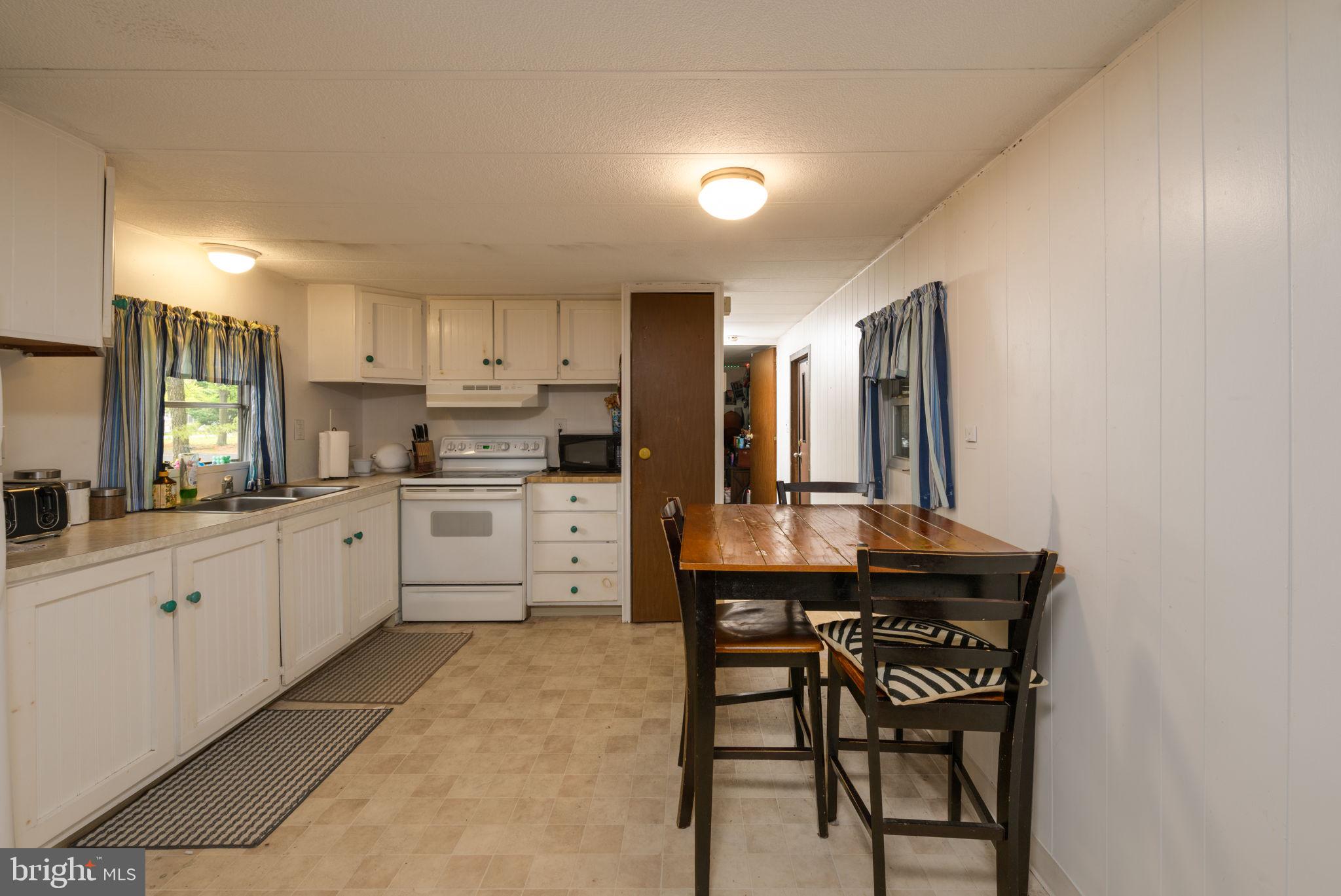 27284 Cottage Road, Unit 9182 Millsboro, DE 19966 - Photo 8 of 18 a kitchen with a sink cabinets and wooden floor