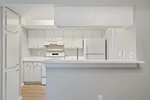 a kitchen with stainless steel appliances cabinets and a window