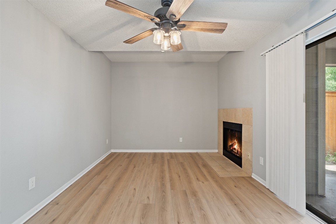 7635 Guadalupe Street, Unit 102 Austin, TX 78752 - Photo 3 of 36 a view of empty room with a fireplace and wooden floor
