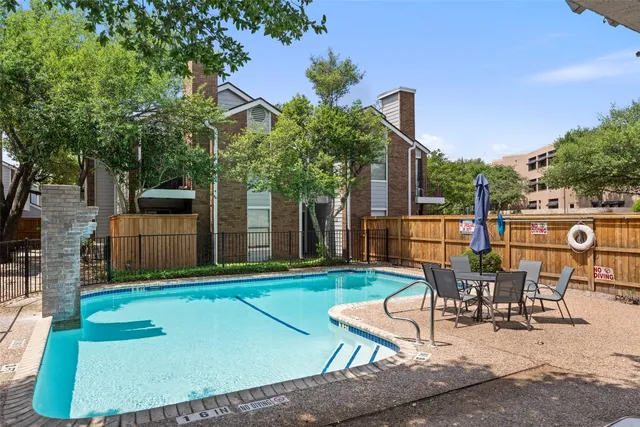 a view of a backyard with table and chairs with wooden fence and plants