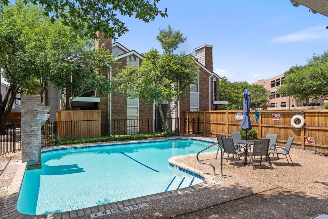 7635 Guadalupe Street, Unit 102 Austin, TX 78752 - Photo 33 of 36 a view of a backyard with table and chairs with wooden fence and plants