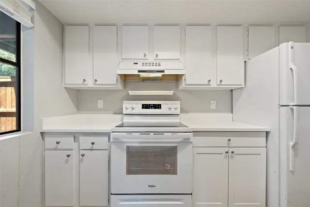 a kitchen with cabinets appliances and a sink