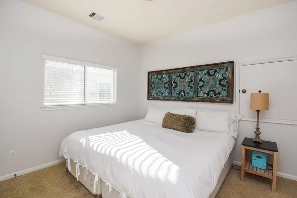 a bedroom with a bed and a night stand