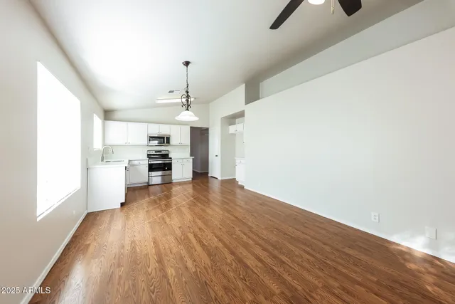 a view of a kitchen with wooden floor electronic appliances and window