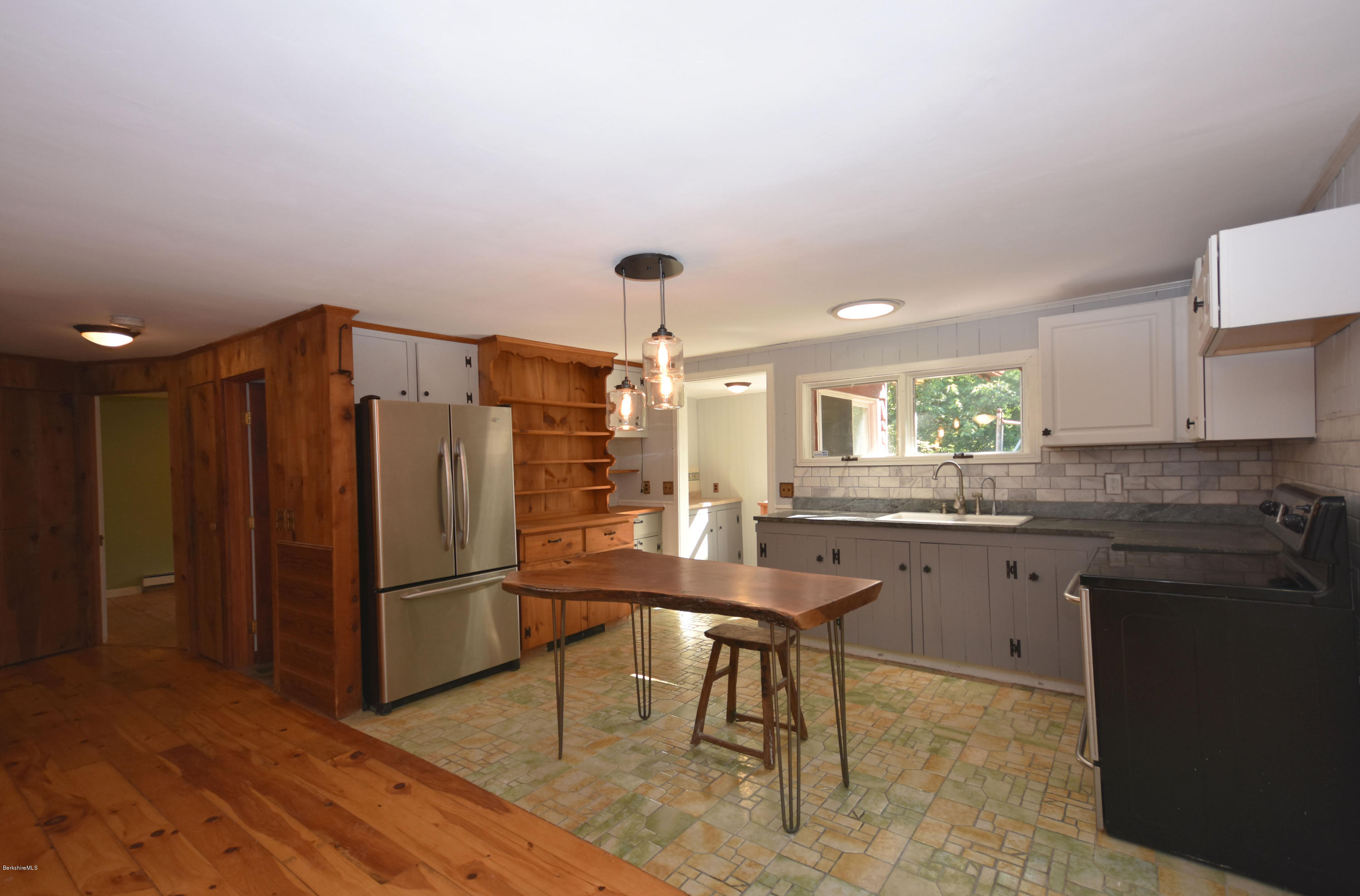 834 George Carter Road Becket, MA 01223 - Photo 21 of 61 a kitchen with granite countertop a refrigerator a stove a sink dishwasher and white cabinets with wooden floor