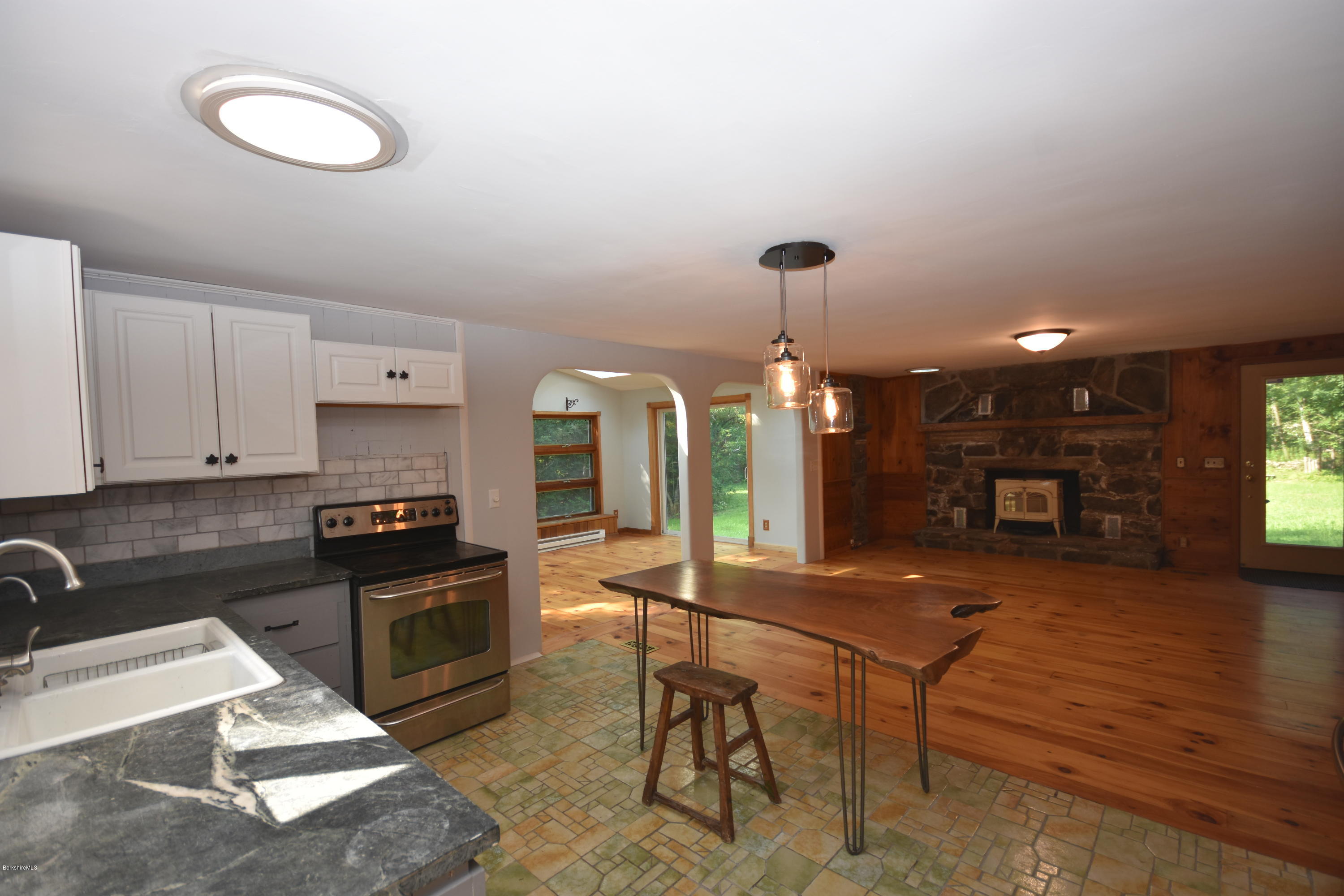 834 George Carter Road Becket, MA 01223 - Photo 22 of 61 a kitchen with stainless steel appliances granite countertop a stove a sink a refrigerator white cabinets and wooden floor
