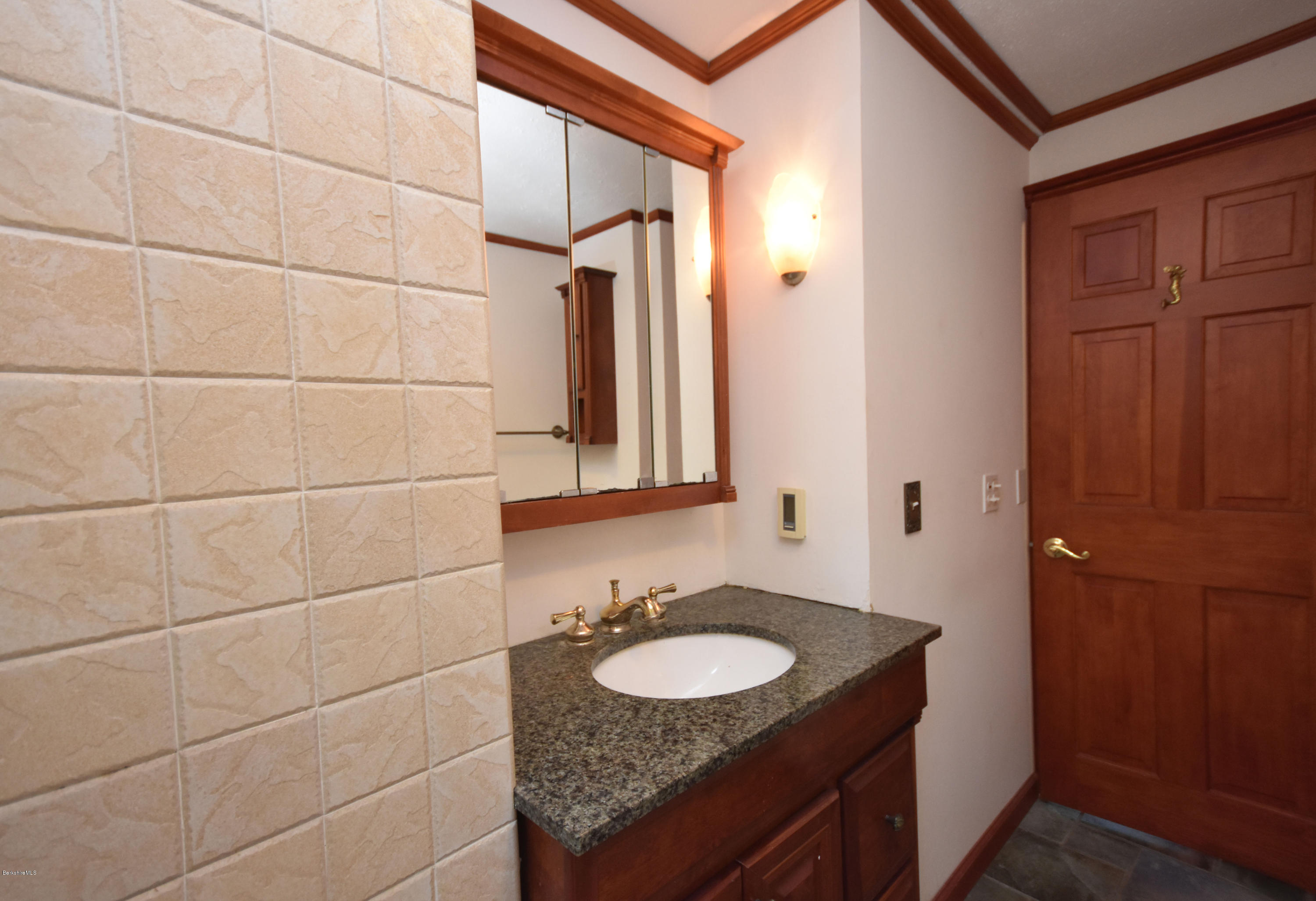 834 George Carter Road Becket, MA 01223 - Photo 36 of 61 a bathroom with a granite countertop sink and a mirror