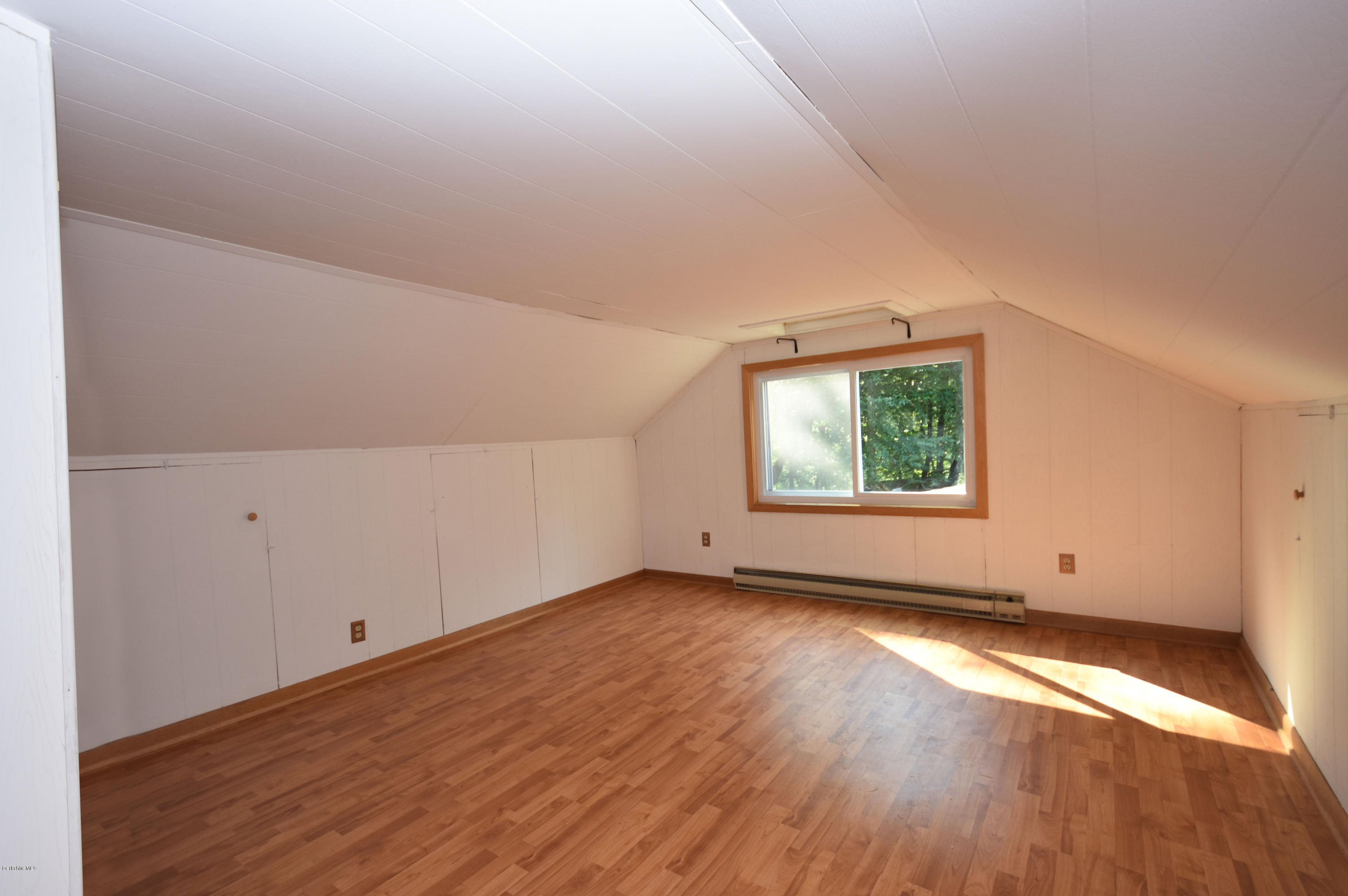 834 George Carter Road Becket, MA 01223 - Photo 38 of 61 an empty room with wooden floor and windows