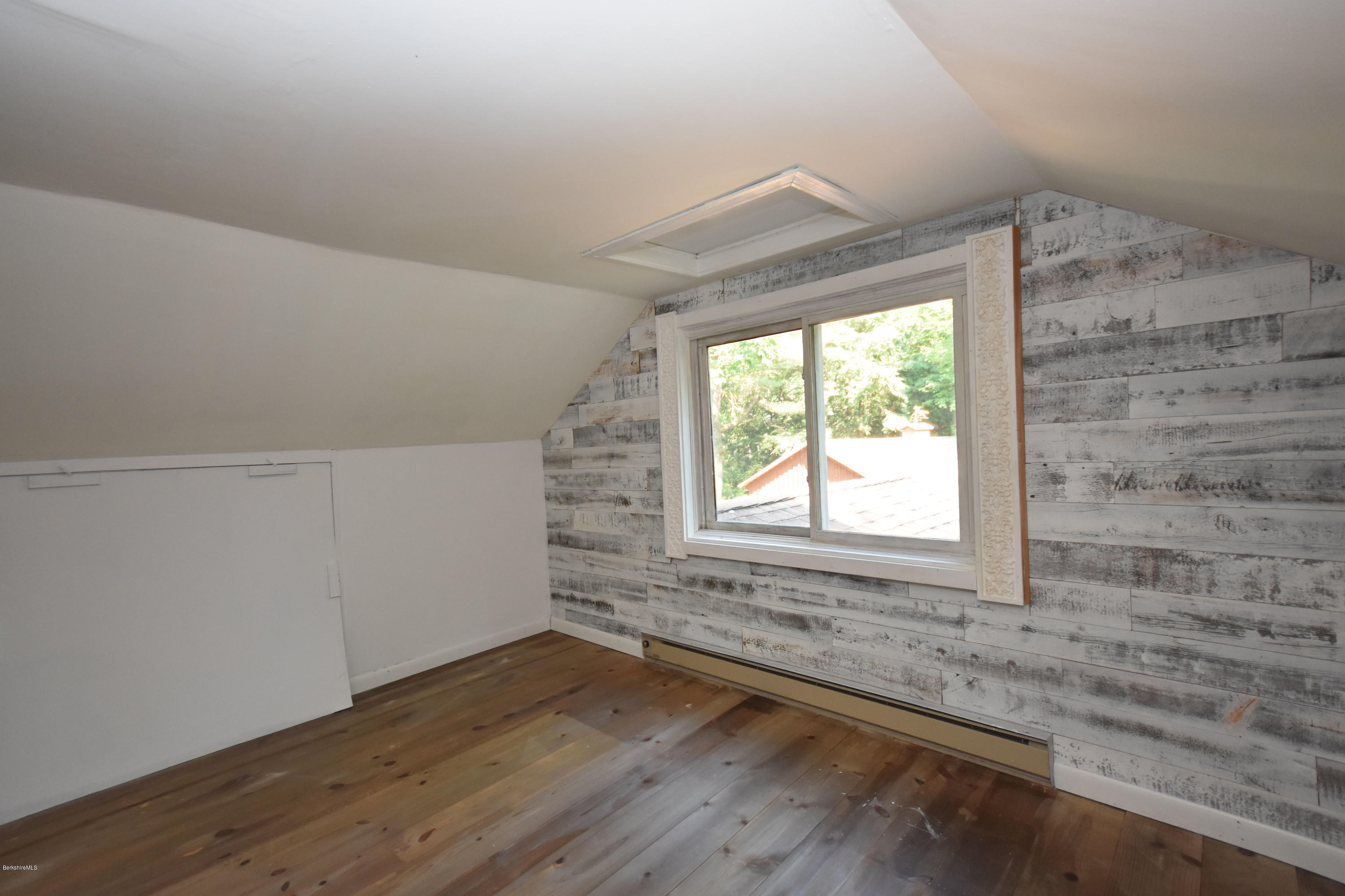 834 George Carter Road Becket, MA 01223 - Photo 42 of 61 an empty room with wooden floor and windows