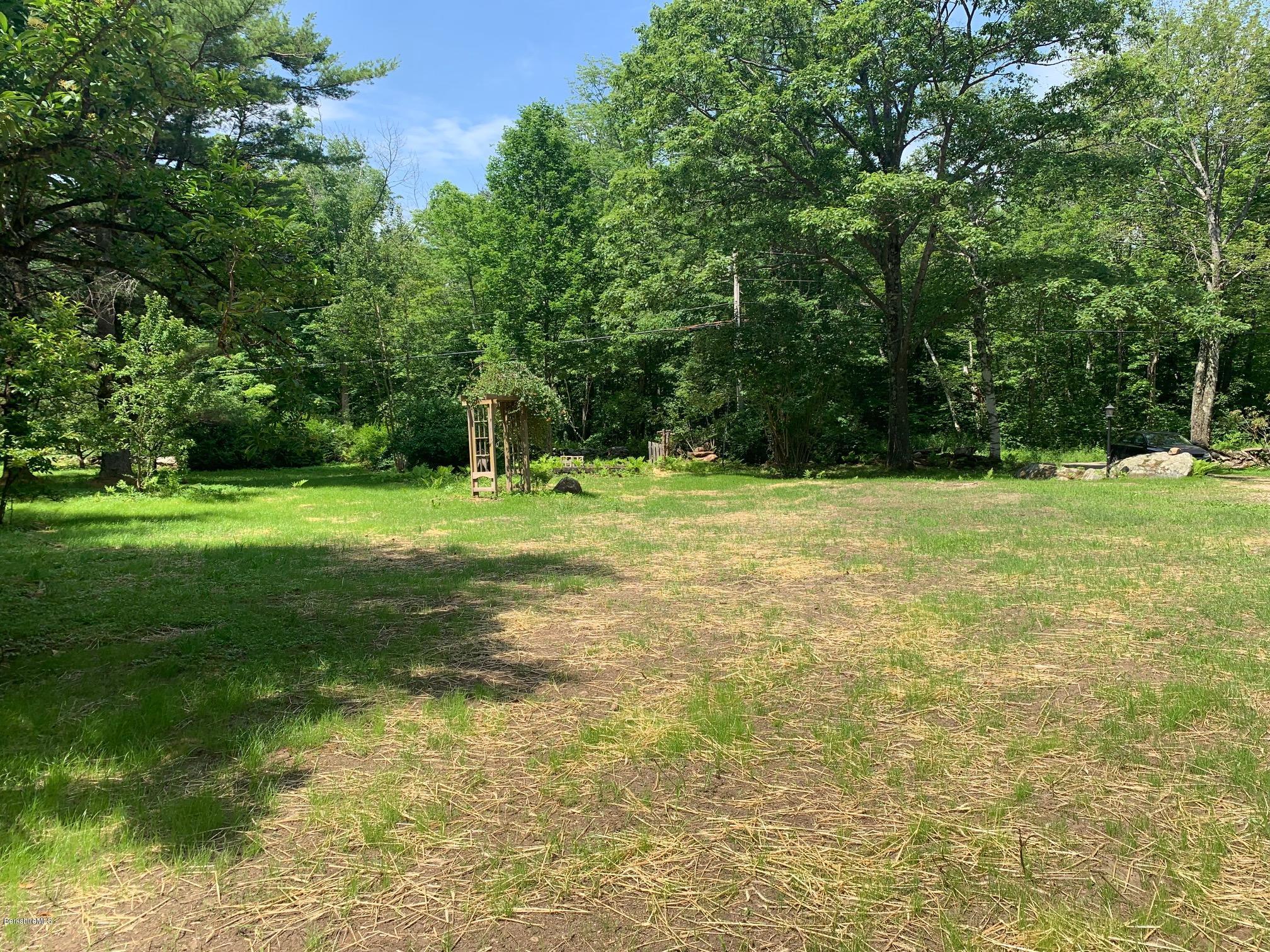 834 George Carter Road Becket, MA 01223 - Photo 57 of 61 a backyard of a house with lots of green space and fountain