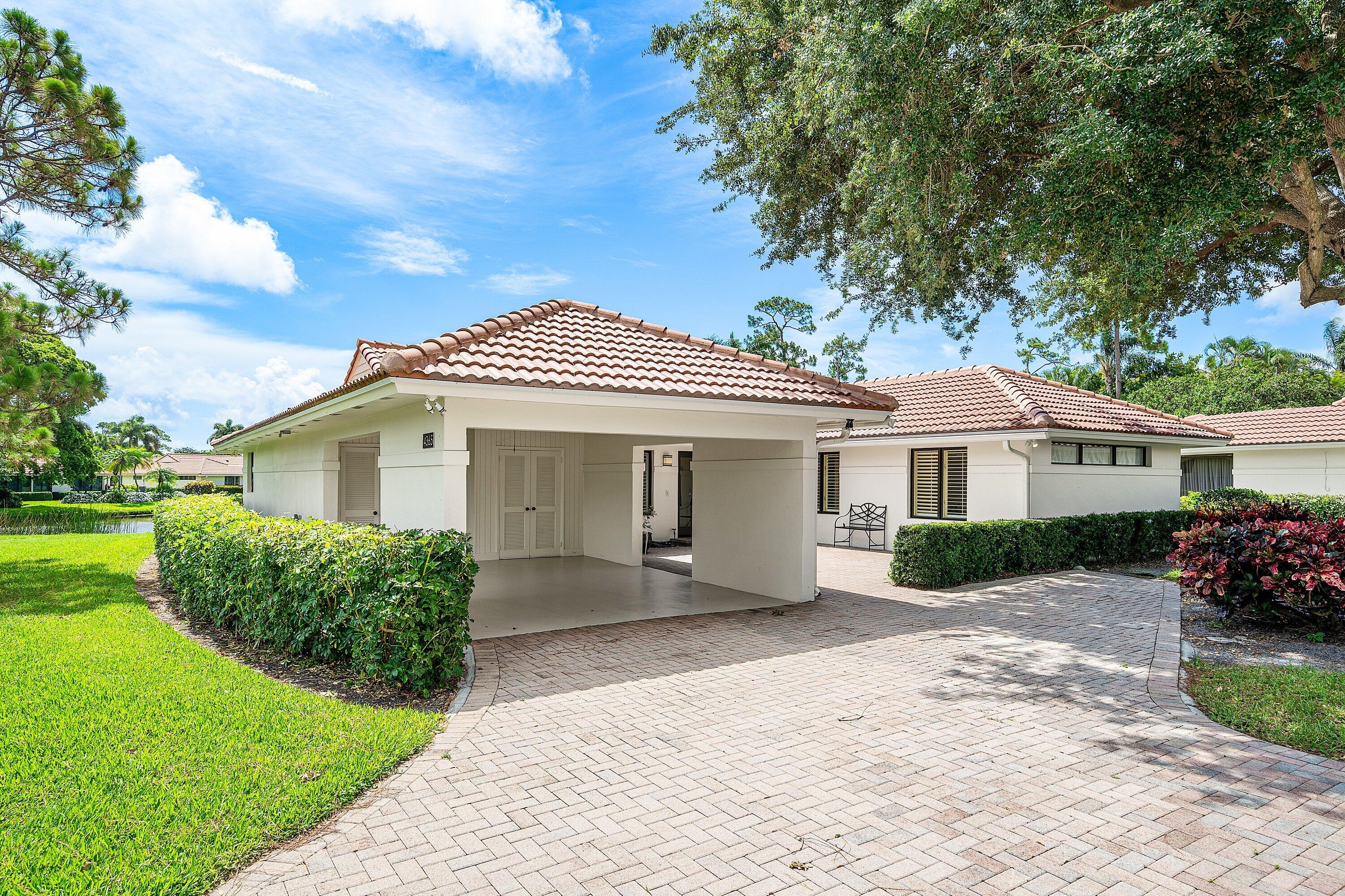 4365 Shell Drake Lane Boynton Beach, FL 33436 - Photo 43 of 56 a front view of a house with a yard and potted plants