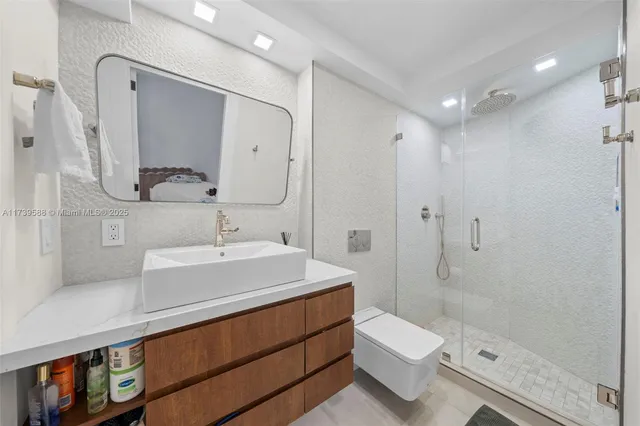 a bathroom with a sink a toilet and shower