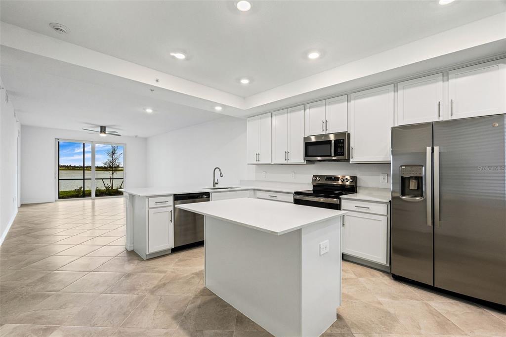 19140 Scallop Loop, Unit 105 Lakewood Ranch, FL 34211 - Photo 3 of 37 a kitchen with stainless steel appliances granite countertop a refrigerator sink and white cabinets