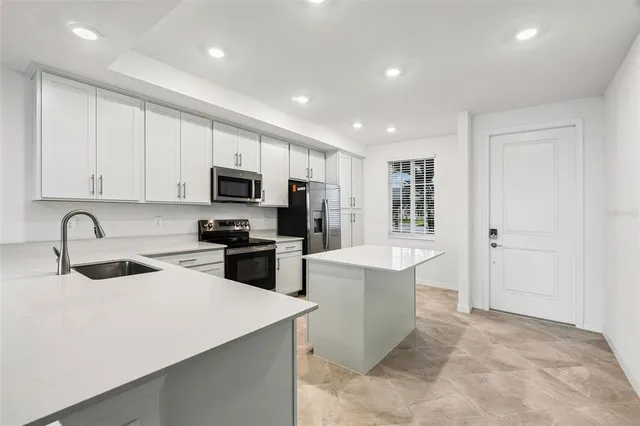 a kitchen with a refrigerator a sink a stove a microwave and cabinets