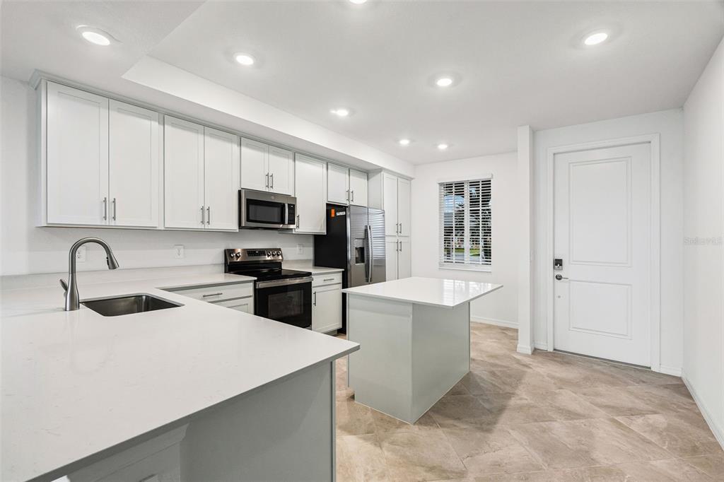19140 Scallop Loop, Unit 105 Lakewood Ranch, FL 34211 - Photo 4 of 37 a kitchen with a sink stainless steel appliances and cabinets
