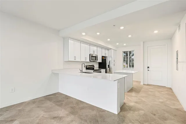 a view of kitchen with stainless steel appliances cabinets
