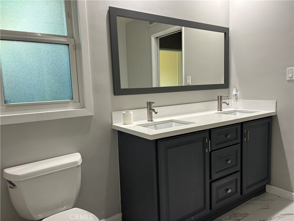 6656 Columbus Avenue Van Nuys, CA 91405 - Photo 11 of 21 a bathroom with a toilet sink and mirror