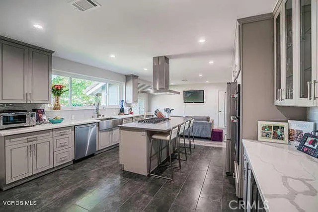 6656 Columbus Avenue Van Nuys, CA 91405 - Photo 2 of 21 a kitchen with kitchen island granite countertop a sink cabinets and wooden floor