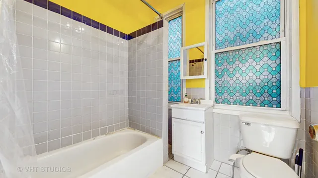 a bathroom with a bathtub a window and a shower