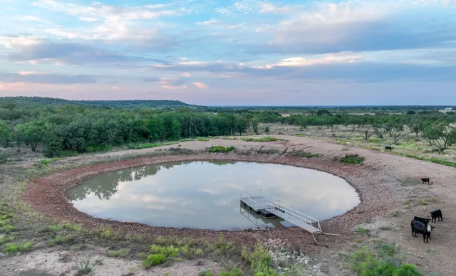 a view of a swimming pool with a yard and fence
