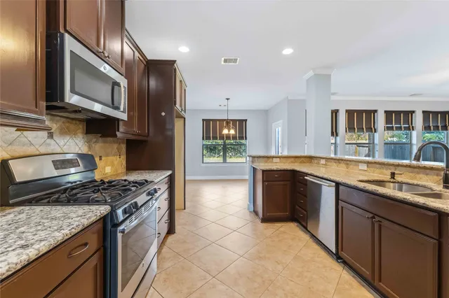 a kitchen with stainless steel appliances granite countertop a sink stove and cabinets