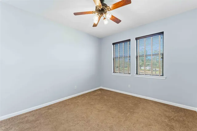 an empty room with chandelier fan