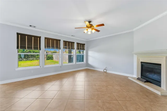 a view of an empty room with a window and fireplace