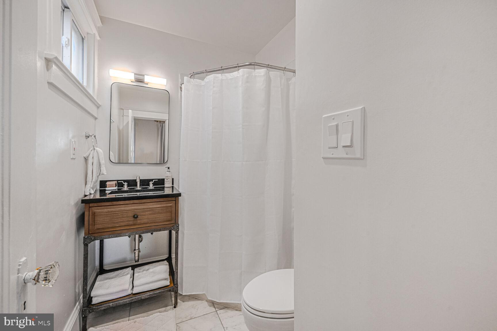 3410 Morrison Street Northwest Washington, DC 20015 - Photo 14 of 71 a bathroom with a toilet a sink and a mirror