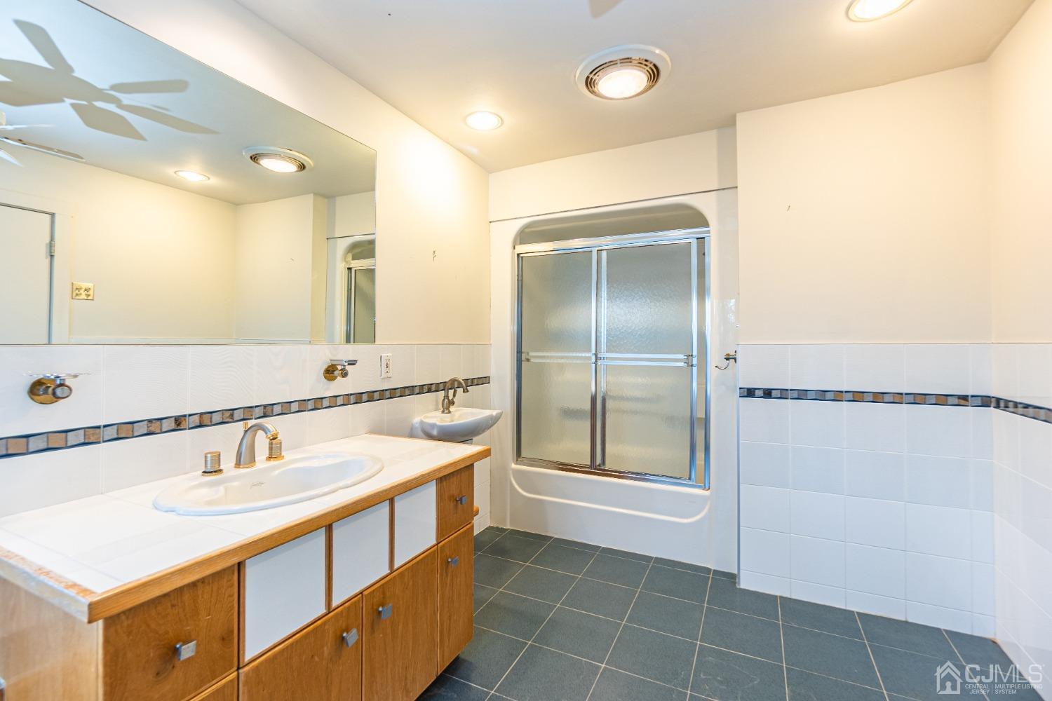 80 Sherwood Road Colonia, NJ 07067 - Photo 32 of 51 a bathroom with a sink a mirror and a shower
