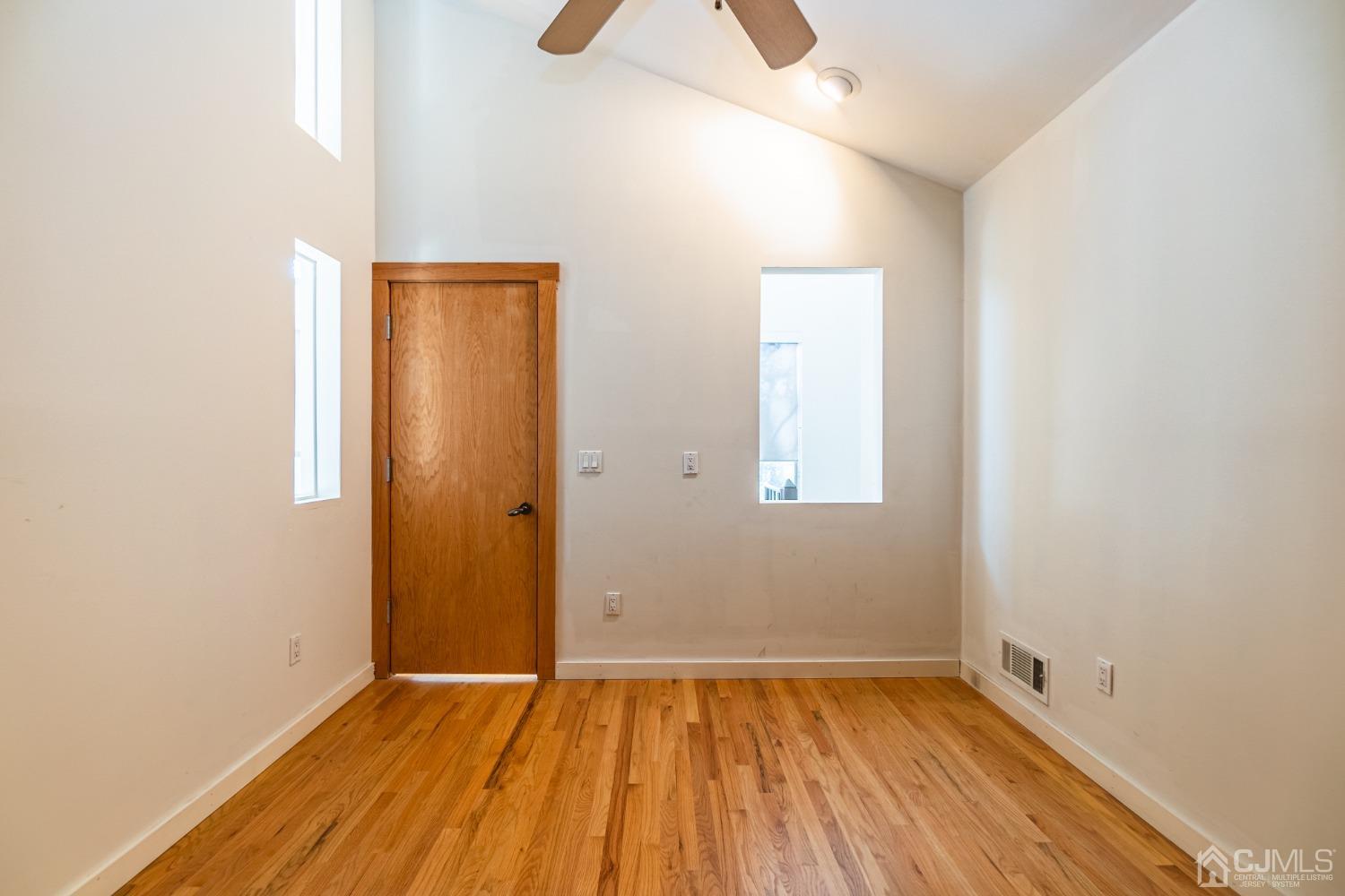 80 Sherwood Road Colonia, NJ 07067 - Photo 42 of 51 an empty room with wooden floor and windows