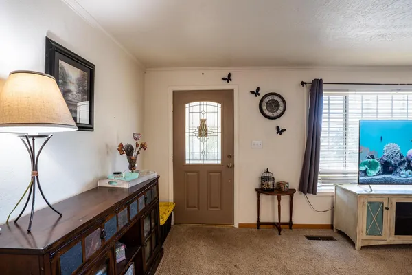 a kitchen with stainless steel appliances kitchen island granite countertop a refrigerator a sink dishwasher a dining table and chairs with wooden floor