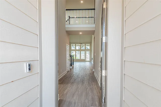 a view of a hallway with wooden floor and a cabinet