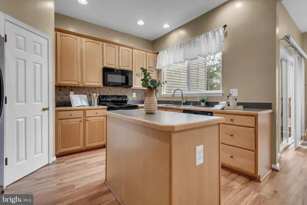 a kitchen with stainless steel appliances a stove refrigerator sink and microwave