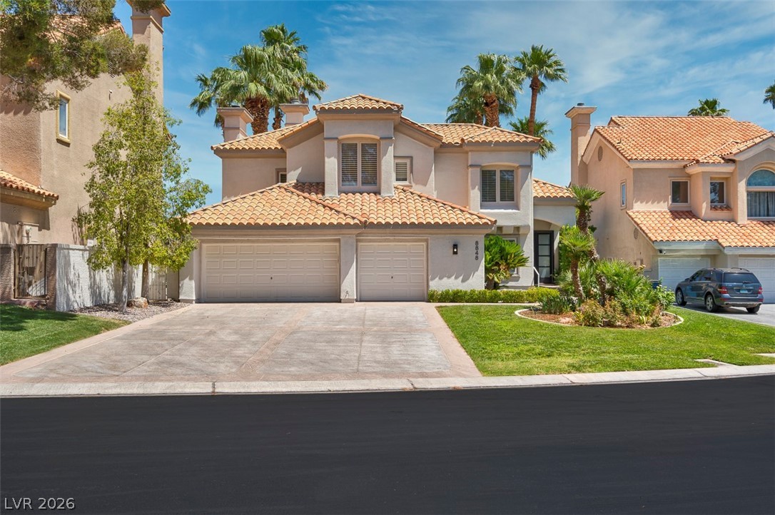 8848 Rainbow Ridge Drive Las Vegas, NV 89117 - Photo 2 of 43 A terracotta-roofed residence with manicured lawns and mature palm trees creates an inviting street presence.