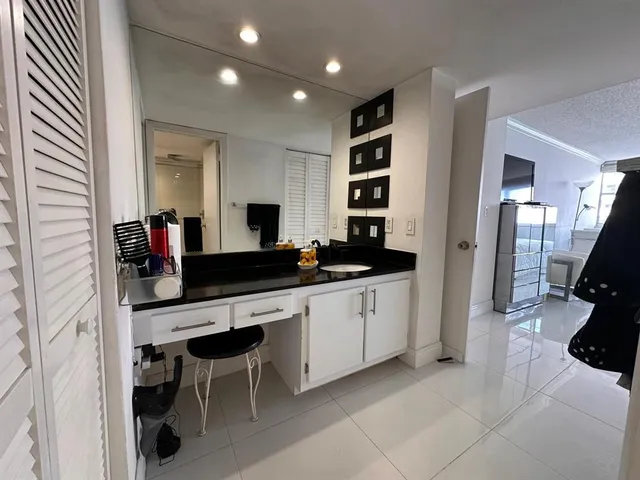a large white kitchen with a sink and furniture